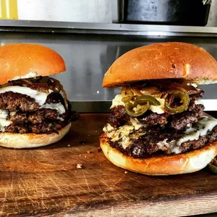 two burgers on a cutting board