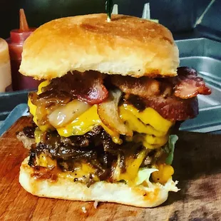 a cheeseburger on a wooden cutting board