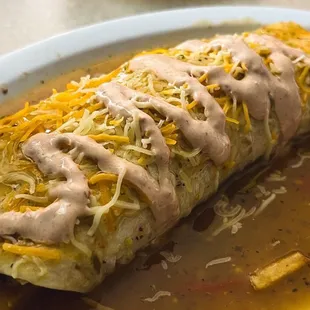 a large burrito with cheese on top