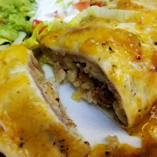 A cut-away of the lunch burrito with carnitas and smothered with green chile.