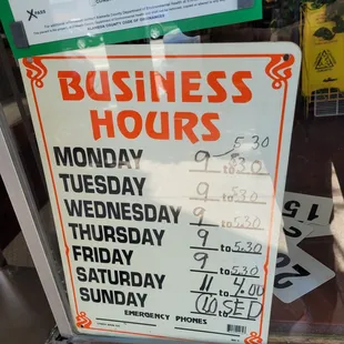 a business hours sign in a window