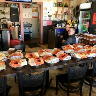 a woman sitting at a table full of pizzas