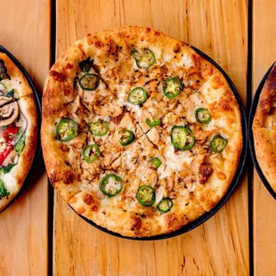 three pizzas on a wooden table