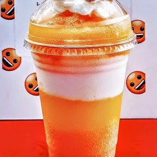 an orange drink with whipped cream and a cherry on top