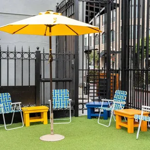 a patio with chairs and an umbrella
