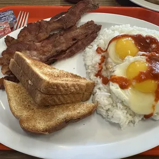 Breakfast plate: rice, eggs, bacon, toast and my hot sauce!