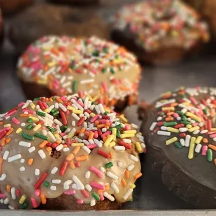 a tray of donuts with chocolate frosting and sprinkles
