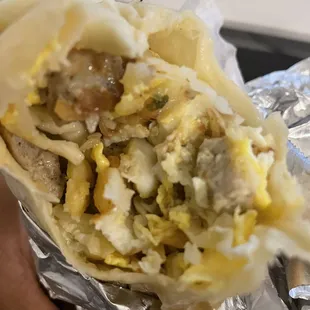 a hand holding a burrito