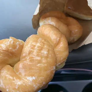 a person holding a bag of doughnuts