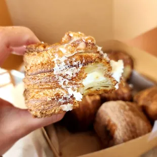 a hand holding a half eaten pastry