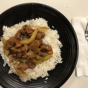 a plate of rice with meat and vegetables