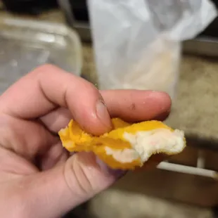 a hand holding a half eaten sandwich