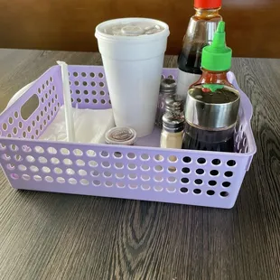 a plastic basket with condiments and condiments