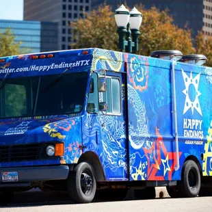 a blue food truck on a city street