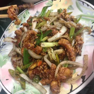 a plate of chinese food with chopsticks