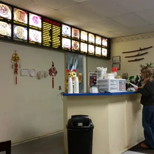 a man standing at the counter of a restaurant