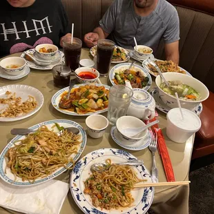 two men sitting at a table full of food