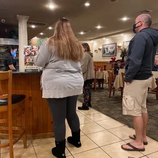 a man and a woman standing at the bar