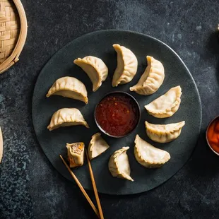 a plate of dumplings with chopsticks