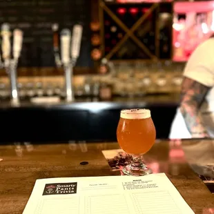a beer and menu on a bar