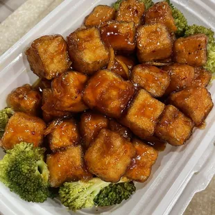 tofu and broccoli in a styrofoam container