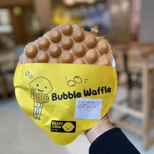 a person holding a bag of bubble waffles