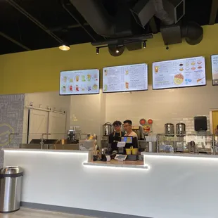 a restaurant counter with menus on the wall