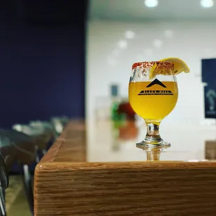 a glass of beer on a bar