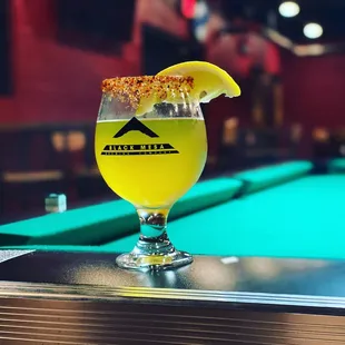 a glass of beer on a pool table