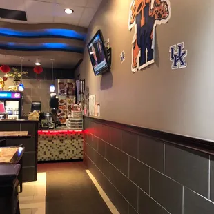 Just past the entrance. If you're dining in have a seat, if you're ordering carry out, stop at the back counter.