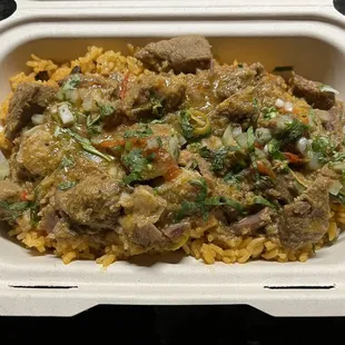 a styrofoam takeout container filled with rice and meat