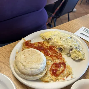 Mushroom &amp; Swiss omelette with hash browns and an English muffin - she added the ketchup.