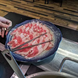 a person cutting meat with chopsticks