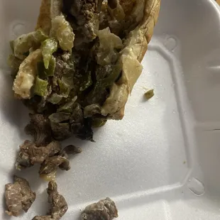 a half eaten sandwich in a styrofoam container
