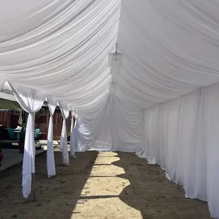 All white draping tent decor with chandeliers