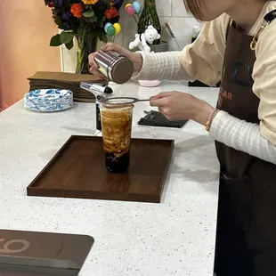 a woman preparing a drink in a kitchen