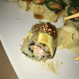 a plate of sushi with chopsticks