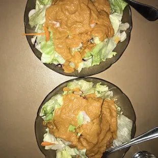 two bowls of salad with dressing