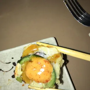 a plate of sushi with chopsticks