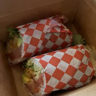 two burritos wrapped in red and white checkered paper