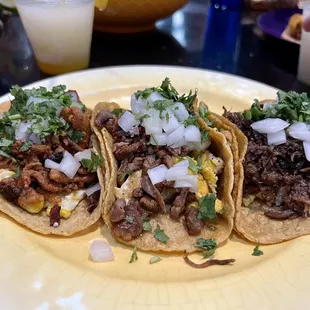 three tacos on a yellow plate