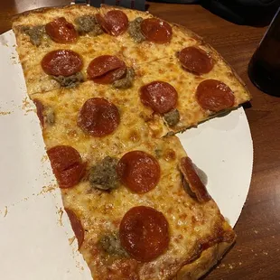 Half eaten sausage and pepperoni pizza