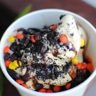 cake batter swirled with cookies and cream topped with reeses pieces, crushed oreo and chocolate fudge