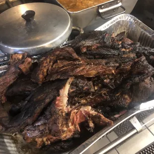 a tray of ribs and a pot of soup
