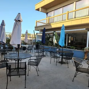 a patio with tables and umbrellas