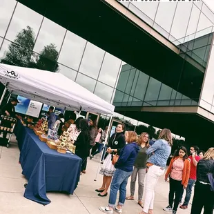 a group of people standing around a table