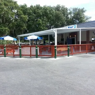 the outside of a restaurant with tables and umbrellas