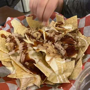 a plate of nachos with pulled pork