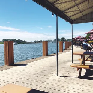 a view of a dock with tables and umbrellas