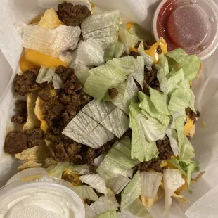 Mini nachos- minus the tomatoes because I&apos;m allergic. The nachos were layered with ground beef, lettuce, and melted cheese. Delicious